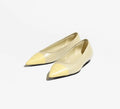 Pair of light-colored pointed-toe shoes on a white background