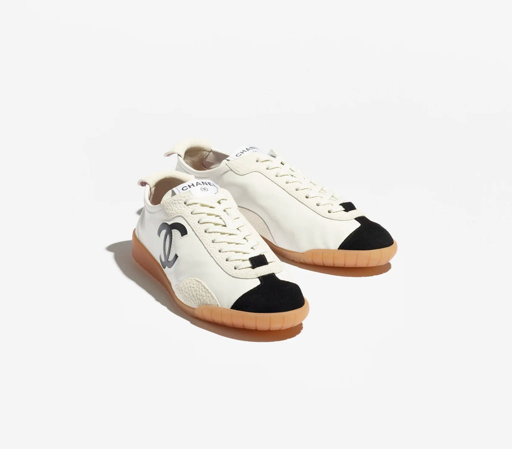 Pair of white sneakers with black accents on a white background