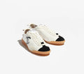 Pair of white sneakers with black accents on a white background